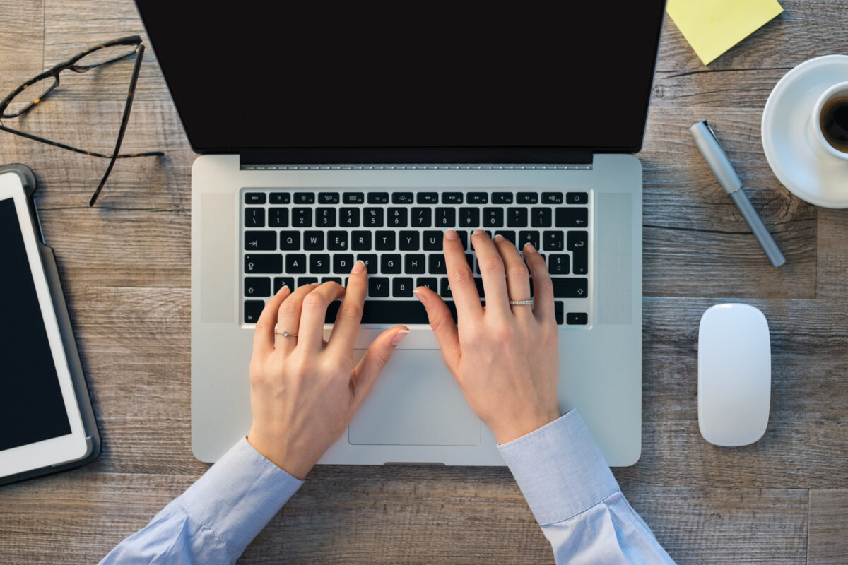 Businesswoman hands typing on laptop